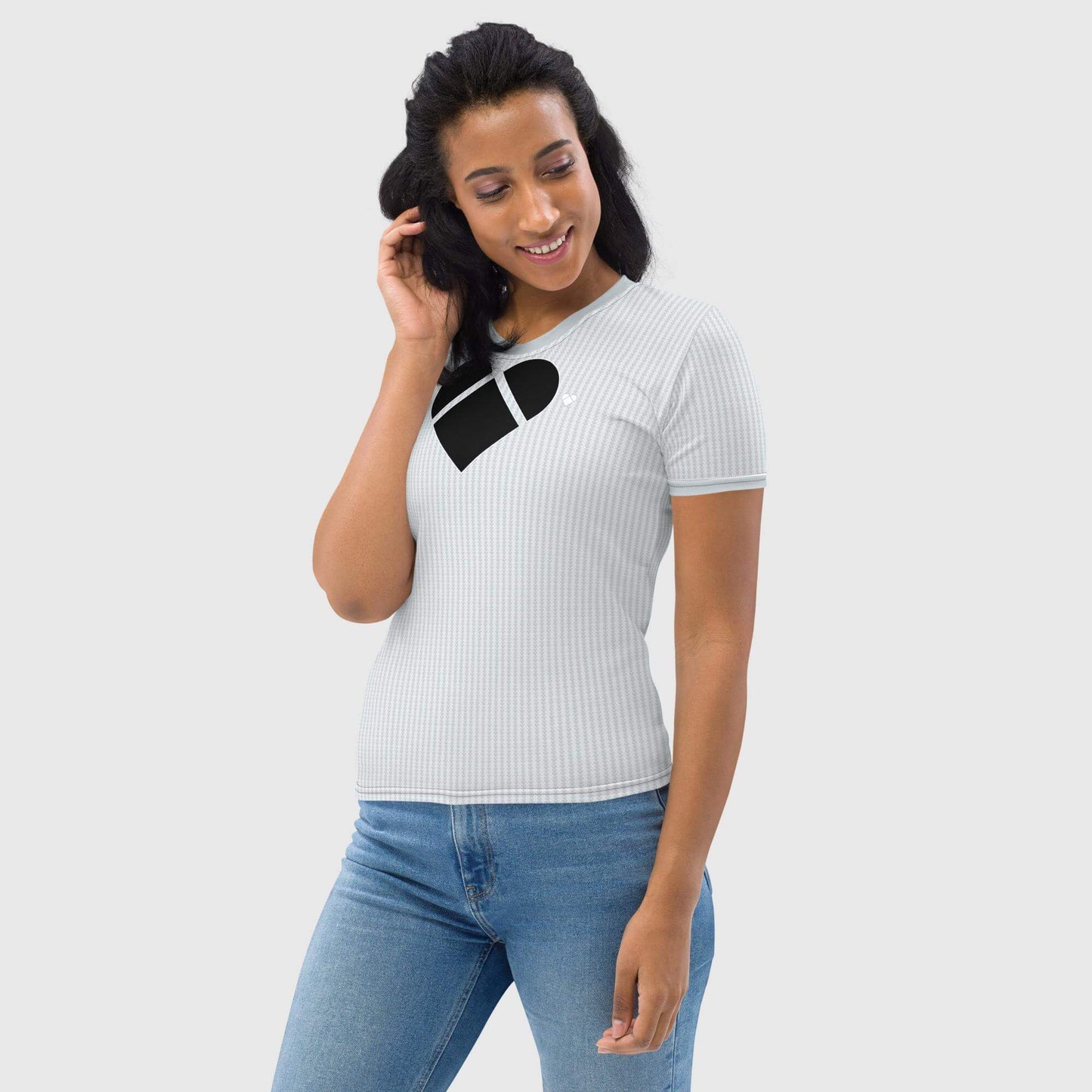 female model wearing Women's Love Armor Shirt in light gray, adorned with a black heart made of dual shade lovograms, a pattern of little heart-shaped geometrical logos.